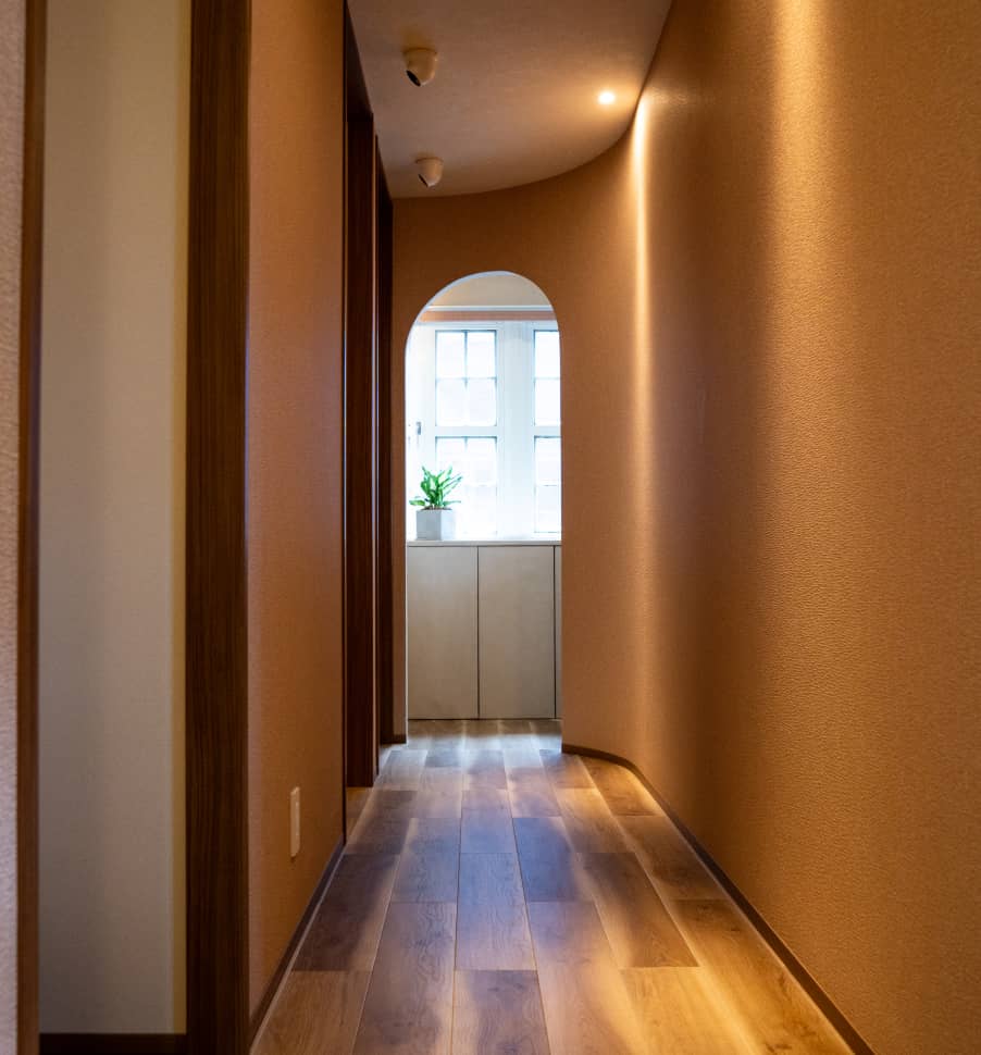 木製の床と温かみのある壁に囲まれたアーチ型の通路