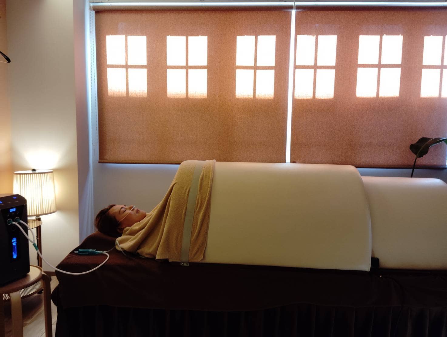 サロンで温熱ドームに入りリラックスする女性