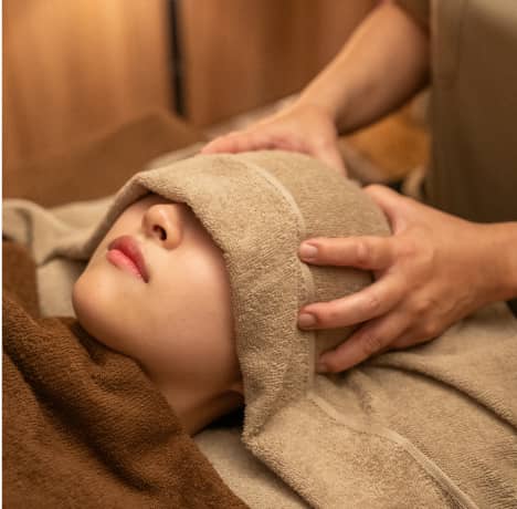 心地よい温かさのホットタオルでリラクゼーションを楽しむ女性